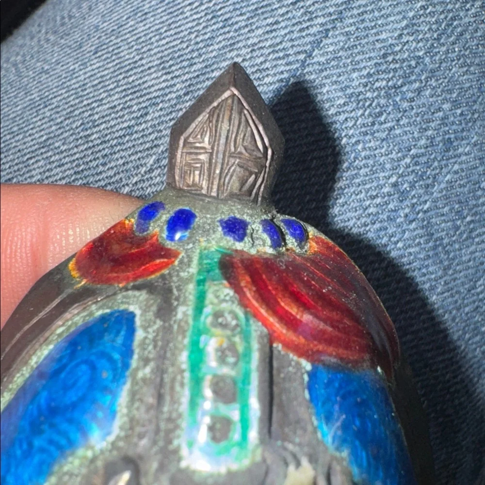 Vintage enameled metal decorative mask of an Asian man's face.